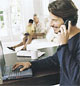 2000's man using his laptop while talking on his mobile phone